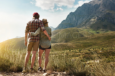 Buy stock photo Rearview shot of a young couple admiring a mountainous view in nature