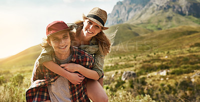 Buy stock photo Portrait of a happy young couple enjoying a piggyback ride in nature