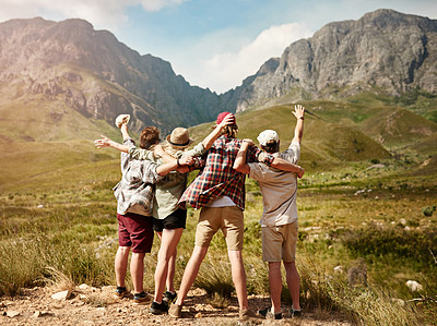 Buy stock photo Rearview shot of a group of friends cheering while admiring a mountainous view in nature