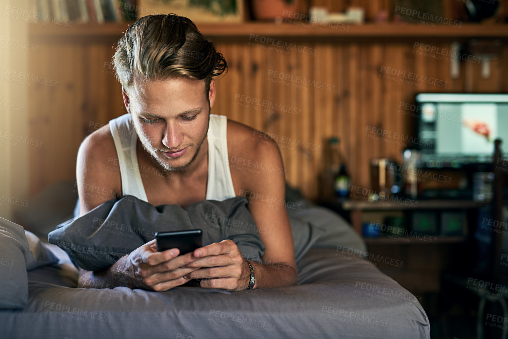 Buy stock photo Happy, home and man on bed with phone for online chatting, communication and networking. Morning, apartment and person typing on smartphone for social media, website and internet relax in bedroom