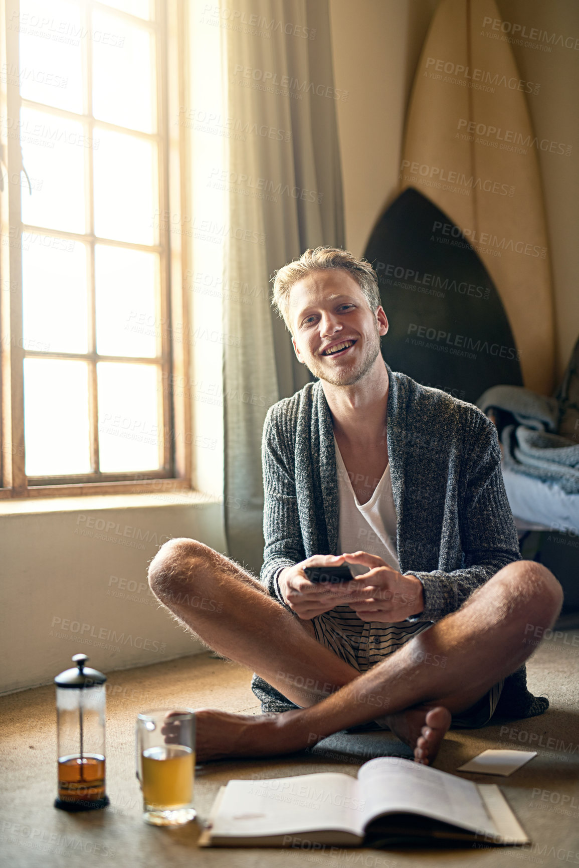 Buy stock photo Portrait of a young man texting on his cellphone at home