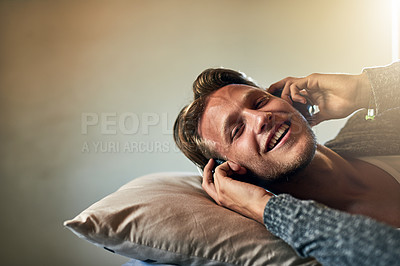 Buy stock photo Portrait of a young man listening to music with headphones on at home