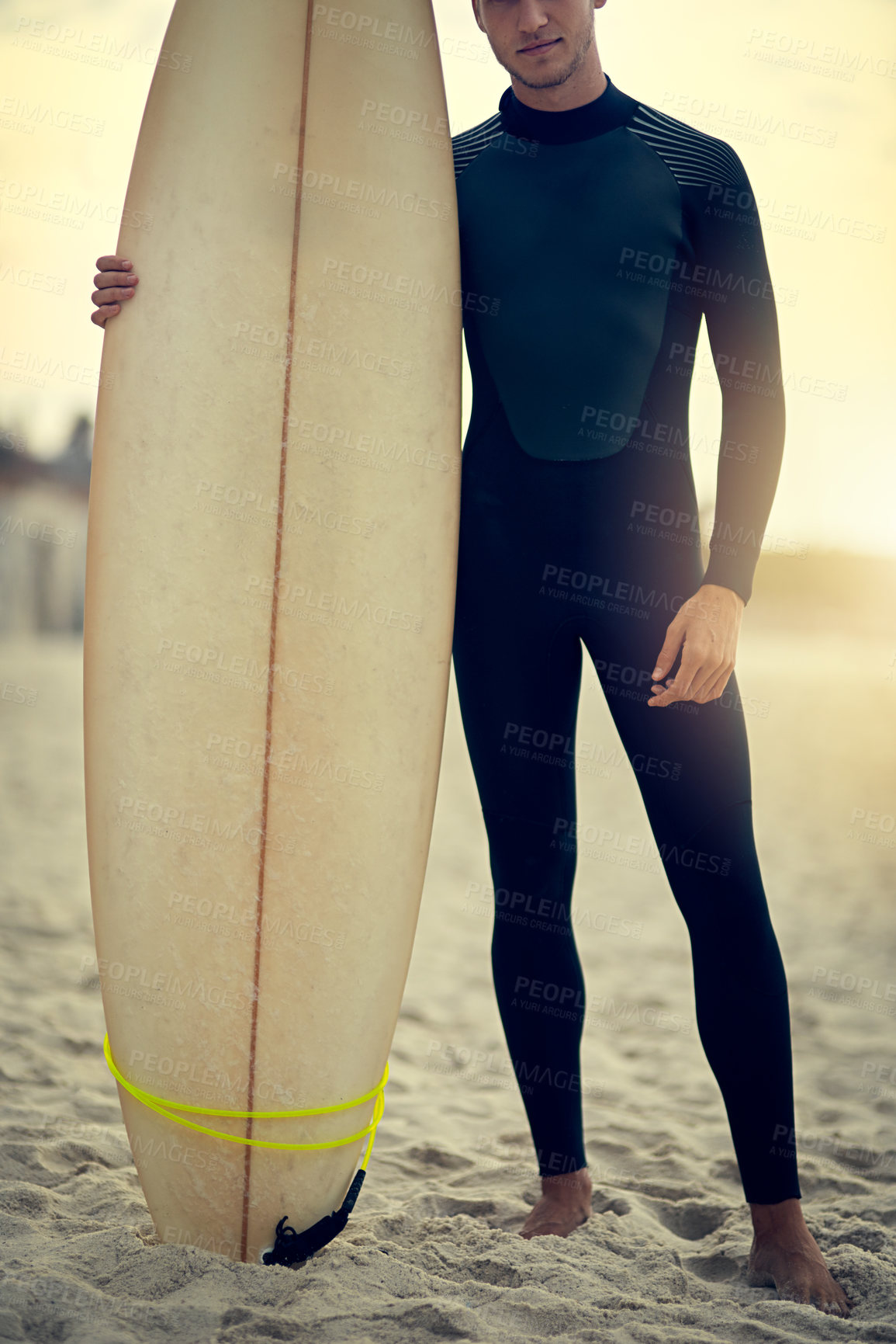 Buy stock photo Shot of an unidentifiable young surfer posing on the beach with his surfboard
