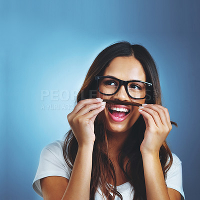 Buy stock photo Studio shot of an attractive young woman playfully making a moustache with her hair against a blue background