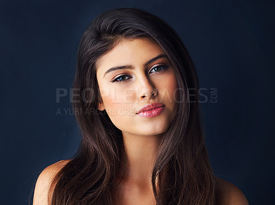 Buy stock photo Cropped portrait of a gorgeous young woman posing against a dark background