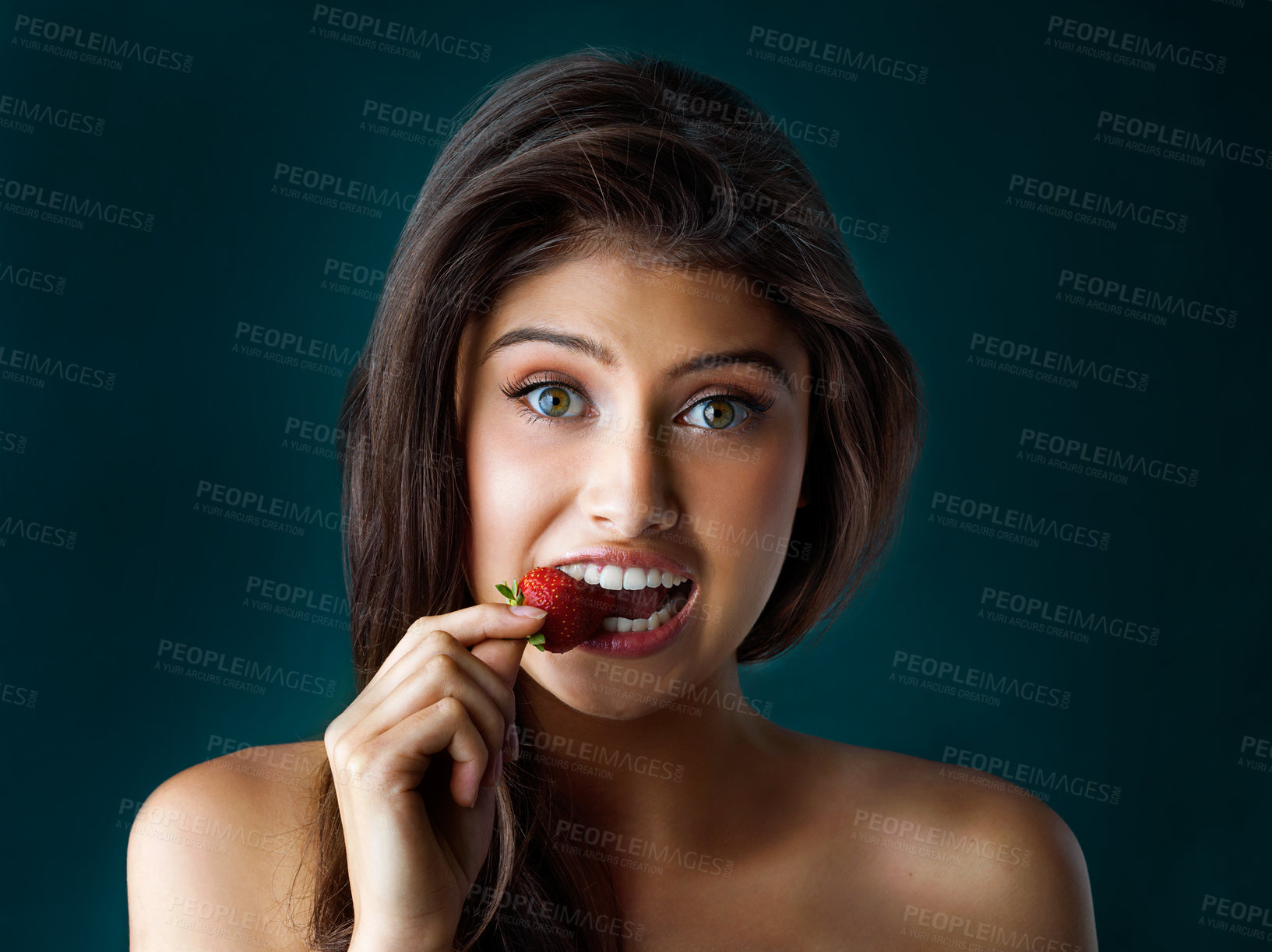 Buy stock photo Beauty, bite or portrait and woman with strawberry in studio on dark background for detox, diet or nutrition. Face, food and wellness with model eat fresh fruit for losing weight or natural vitamins