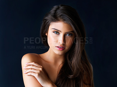 Buy stock photo Cropped portrait of a gorgeous young woman posing against a dark background