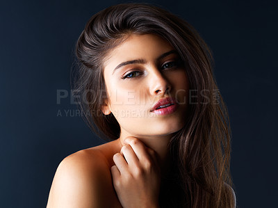 Buy stock photo Cropped portrait of a gorgeous young woman posing against a dark background