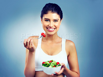 Buy stock photo Woman, portrait and happy, salad and vegetable for health and nutritionist in isolated blue background. Vegan, face and enjoyment, diet with female model in studio and tasting organic food in bowl