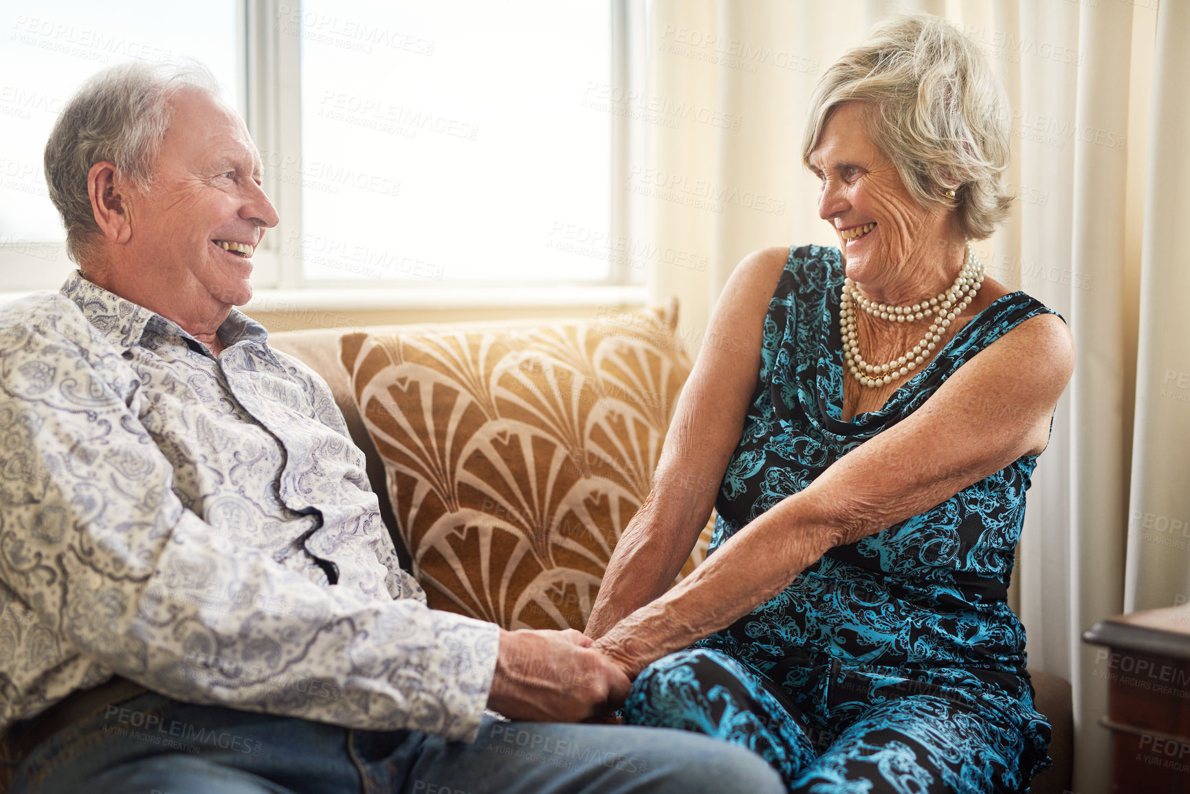 Buy stock photo Senior, couple and holding hands at nursing home with love, smile and bonding in living room. Retirement, care and relax in a house happy with wellness on a sofa with marriage and support together