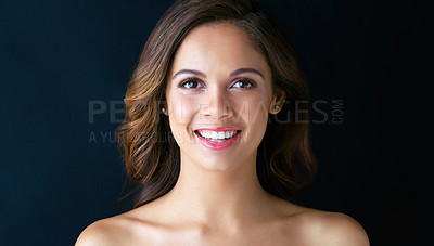 Buy stock photo Portrait of a beautiful young woman posing against a dark background