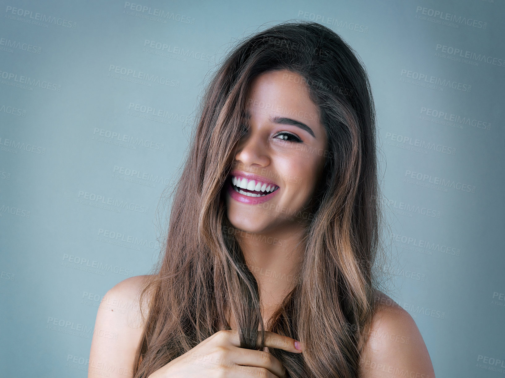 Buy stock photo Happy, woman and portrait with hair care in studio for salon treatment, shine and satisfaction. Relax, smile and female person with confidence for shampoo growth, glow and balayage on blue background