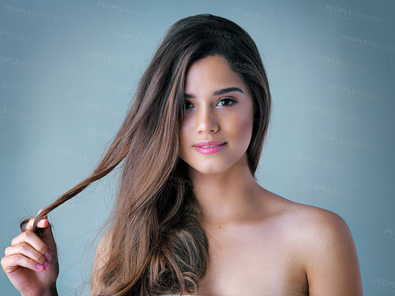 Buy stock photo Happy woman, portrait and haircare with makeup for cosmetics, salon or spa on a blue studio background. Attractive, young female person or model with smile for hair treatment, beauty or cosmetology