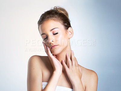 Buy stock photo Studio shot of a beautiful young woman with her eyes closed touching her neck and face