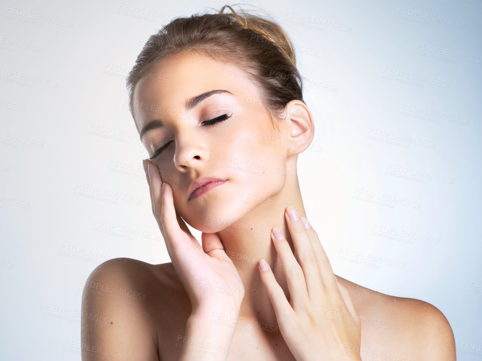 Buy stock photo Studio shot of a beautiful young woman with her eyes closed touching her neck and face