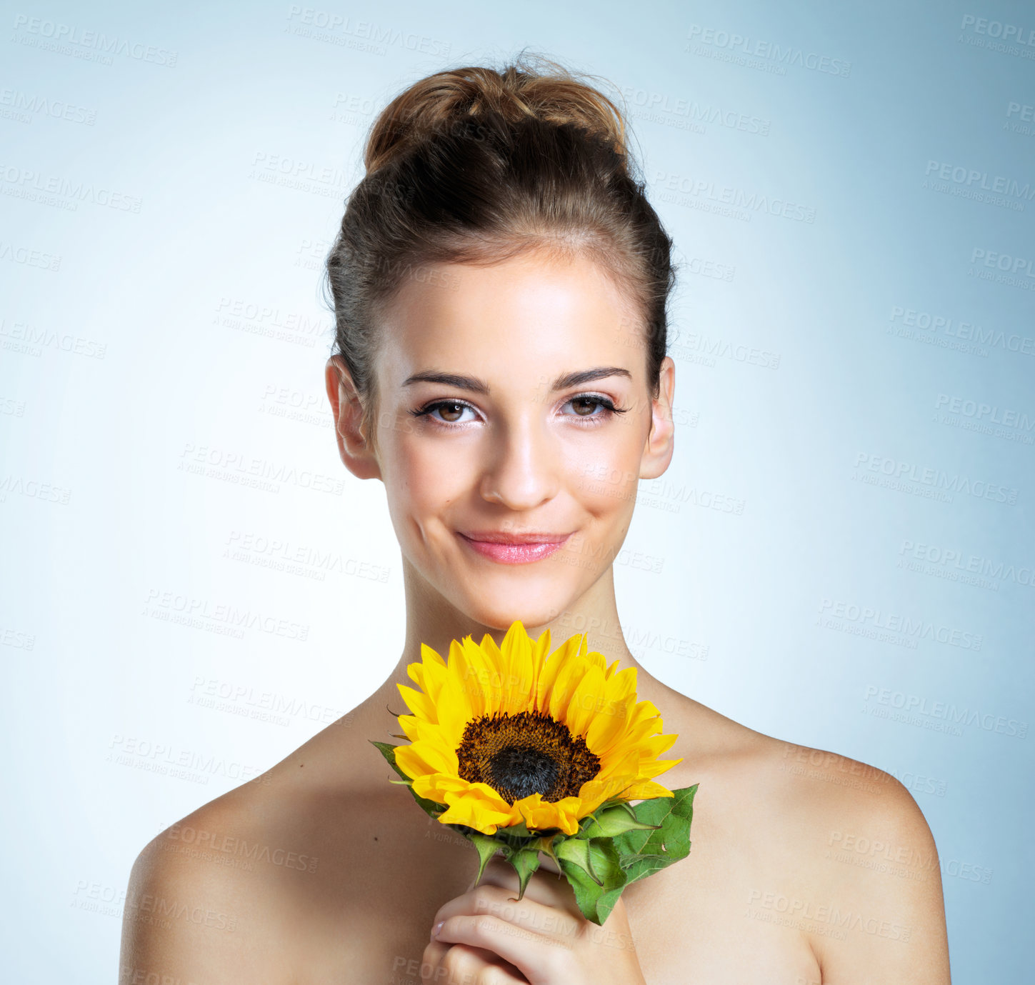 Buy stock photo Sunflower, makeup and portrait of woman in studio with natural, organic and beauty facial makeover. Glow, cosmetics and person with yellow floral plant for cosmetology face routine by blue background