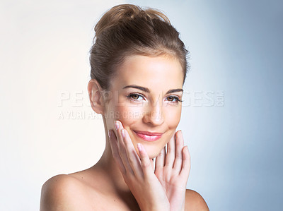 Buy stock photo Studio portrait of a beautiful young woman smiling with her hands on her chin