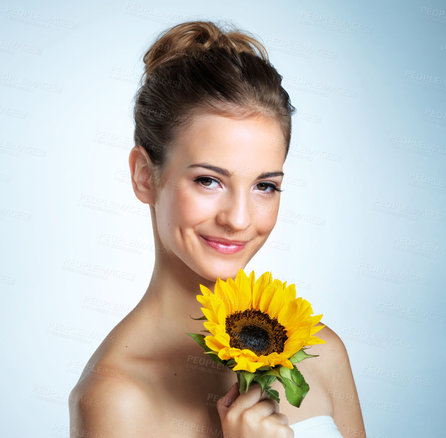 Buy stock photo Sunflower, portrait and woman in studio with cosmetics, organic and beauty facial makeover. Glow, natural and female person with yellow floral plant for cosmetology face routine by blue background.