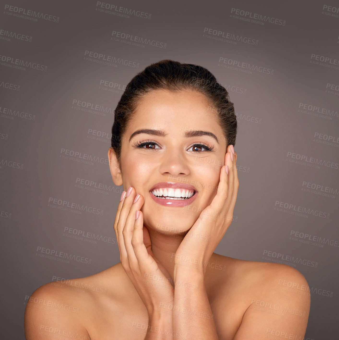 Buy stock photo Studio portrait of a beautiful young woman feeling her skin against a gray background