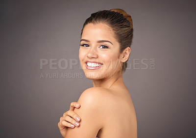 Buy stock photo Studio portrait of a beautiful young woman with flawless skin posing against a gray background