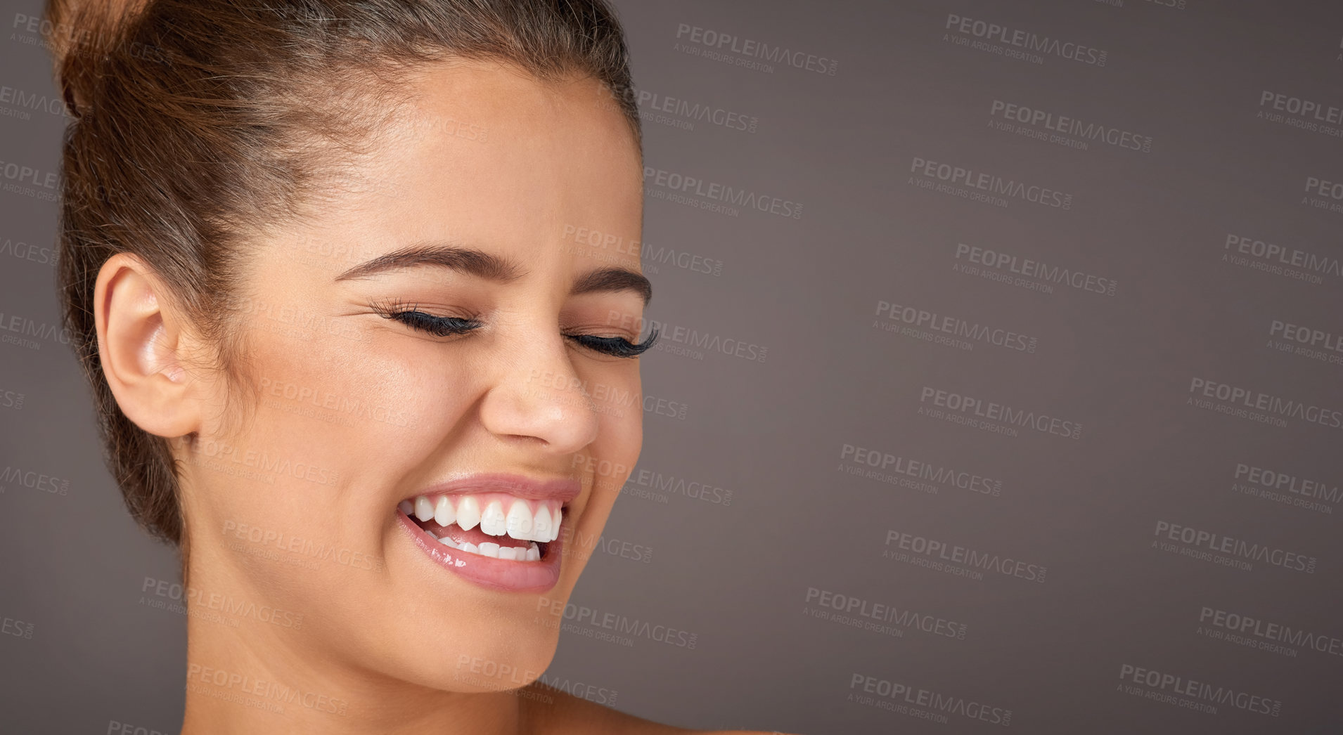Buy stock photo Studio shot of a beautiful young woman laughing against a gray background
