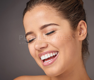 Buy stock photo Studio shot of a beautiful young woman laughing against a gray background