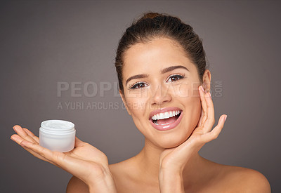 Buy stock photo Portrait of a beautiful young model  holding up a tub of skin cream in studio