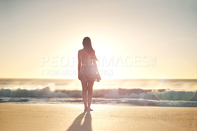 Buy stock photo Rearview shot of a young woman standing on the beach