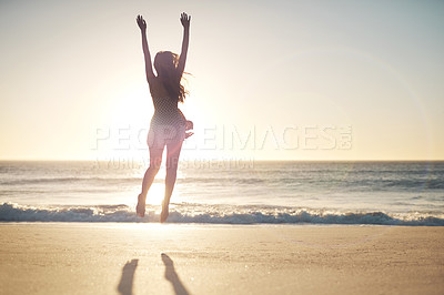 Buy stock photo Shot of a young woman jumping into mid air at the beach