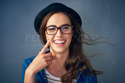 Buy stock photo Portrait of a quirky young woman smiling against a gray background in studio