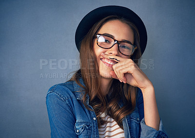 Buy stock photo Shot of a comical young woman posing with a mustache drawn on her finger in studio