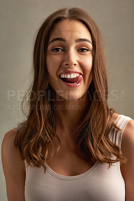 Buy stock photo Happy, tongue out and portrait of woman in studio with smile for emotion, excited and emoji reaction. Comic, attractive and isolated person with funny, silly and goofy face on brown background