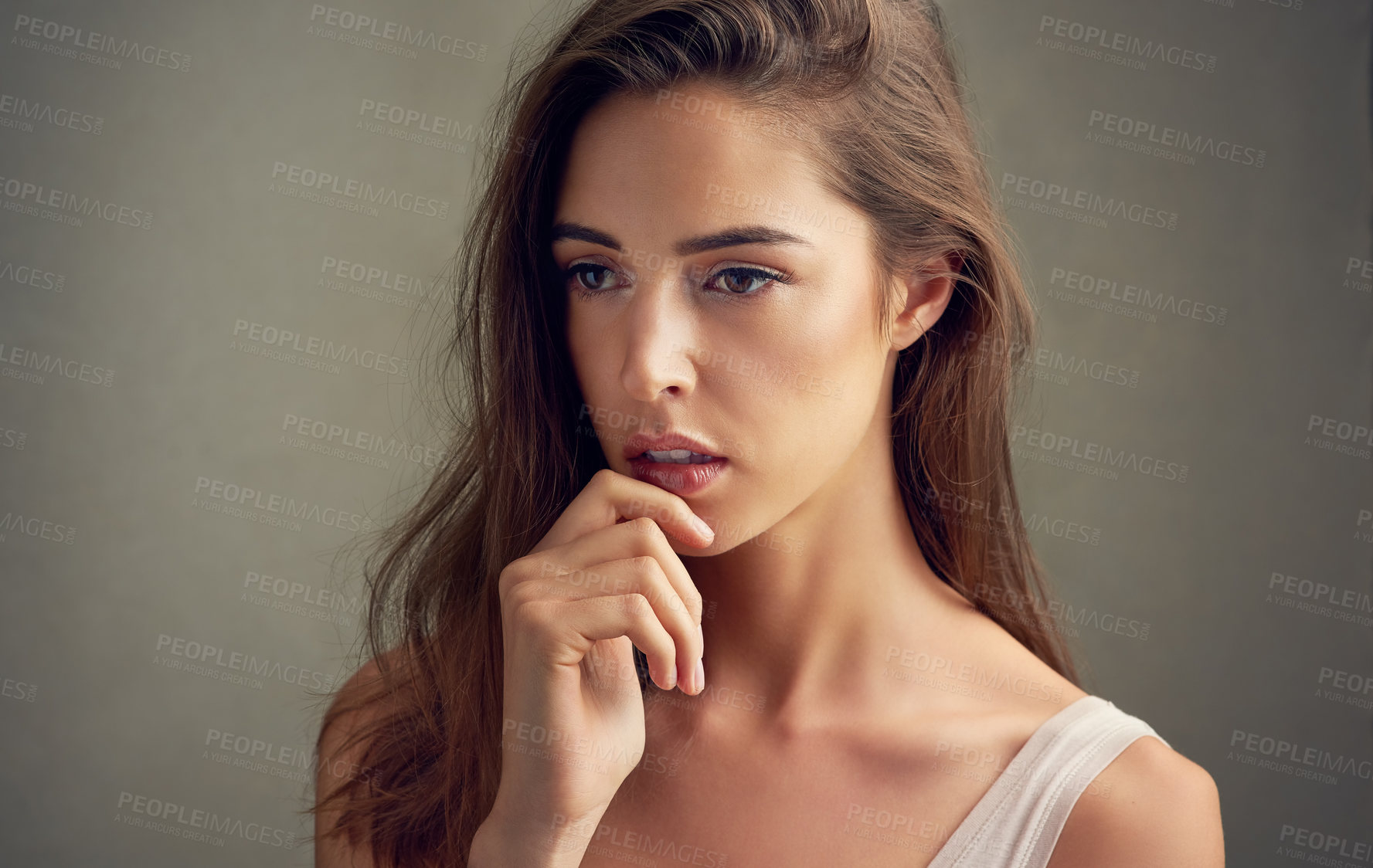 Buy stock photo Studio shot of an attractive young woman standing against a brown background