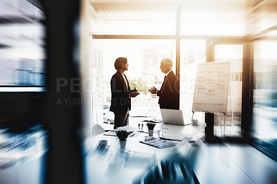 Buy stock photo Shot of two business colleagues talking together in a boardroom