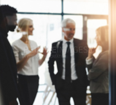 Buy stock photo Defocused shot of a group of businesspeople having a discussion in an office