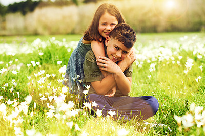Buy stock photo Portrait of a cute little girl giving her big brother a hug outside