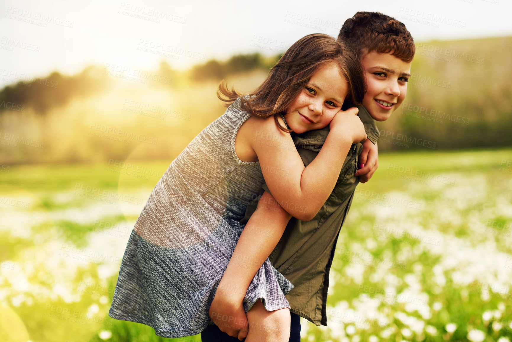 Buy stock photo Portrait of an adorable little boy giving his little sister a piggyback ride outside