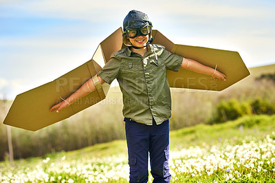 Buy stock photo Shot of a playful little boy pretending to be an airplane with a pair of cardboard wings