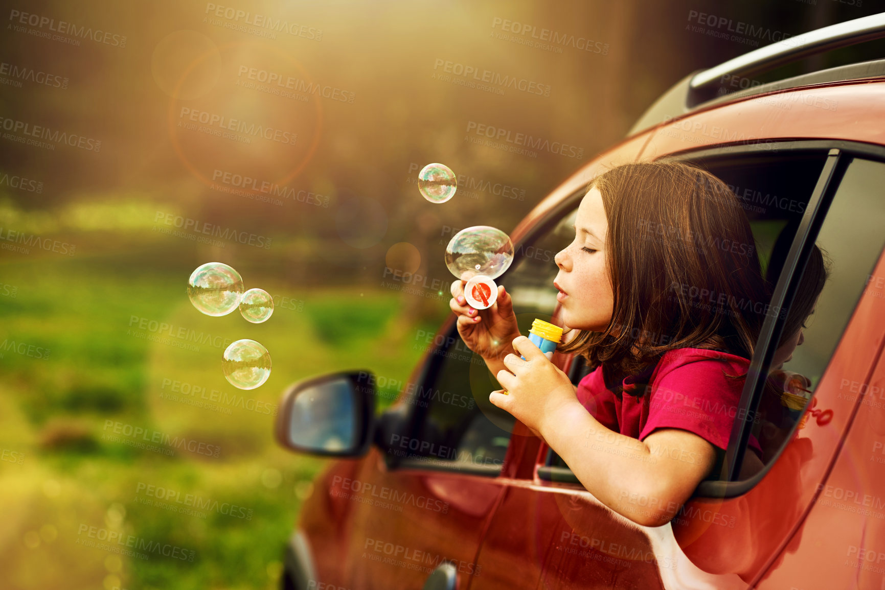 Buy stock photo Blowing, bubbles and kid for fun by window in nature, outdoor or countryside in Australia. Child, girl and game in car for playing, freedom and childhood development of learning with soap toys