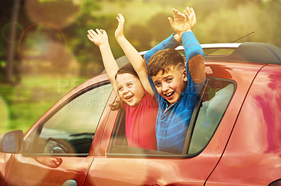 Buy stock photo Shot of two excited children leaning out of a car window together
