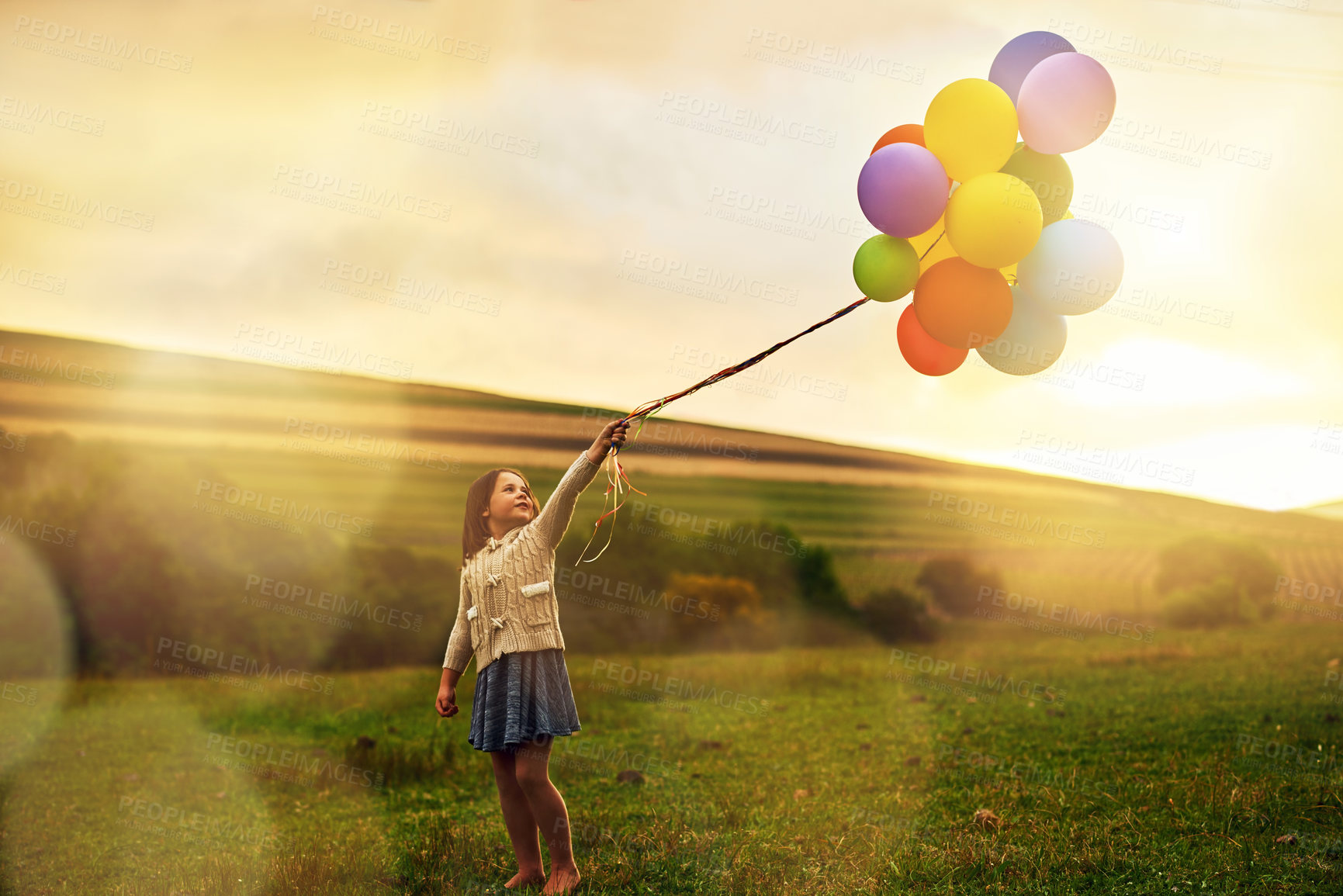 Buy stock photo Nature, girl or kid with balloons for walking, running and playing on grass field with scenic view. Australia, countryside and outdoor with child with energy, inspiration and celebration in park