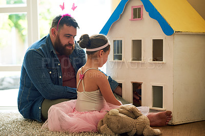 Buy stock photo Shot of an adorable little girl and her father playing with a dollhouse together at home