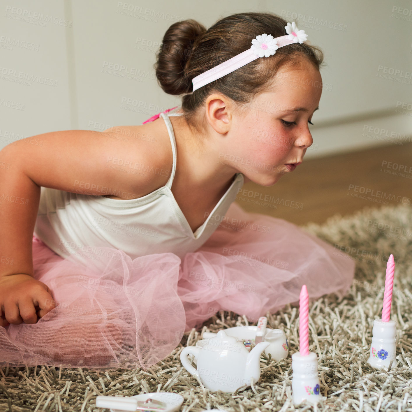 Buy stock photo Girl, tea party and picnic in home with blowing candles, happy and toys for growth or learning. Kid, make believe and joy as youth in playroom for memory or child development in apartment for fun