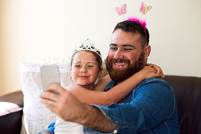 Buy stock photo Shot of an adorable little girl playing dress up and taking selfies with her father at home