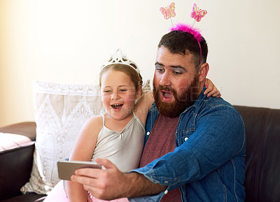 Buy stock photo Shot of an adorable little girl playing dress up and taking selfies with her father at home