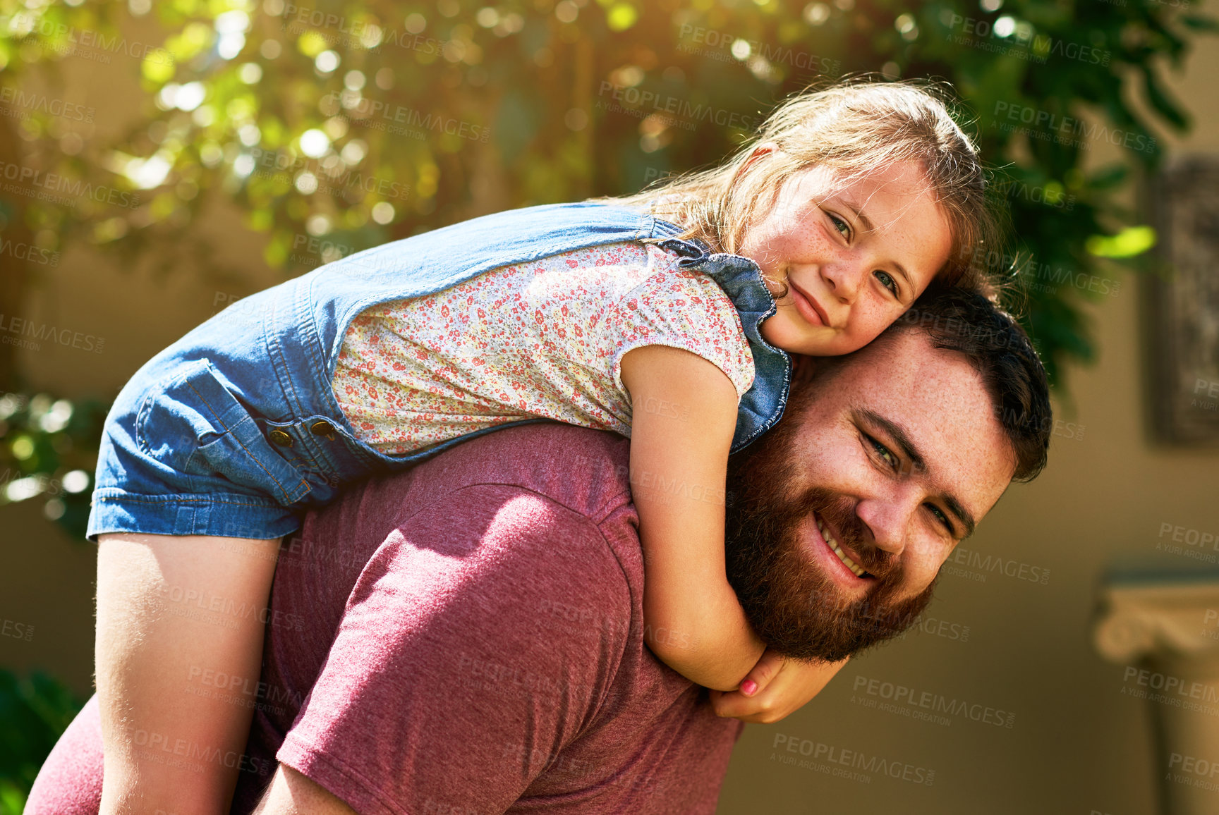 Buy stock photo Shot of an adorable little girl enjoying a piggyback ride from her father in their backyard