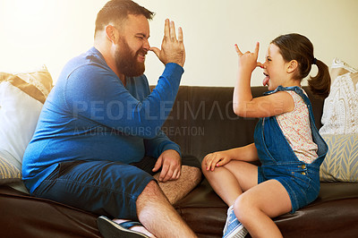 Buy stock photo Shot of an adorable little girl and her father teasing each other at home