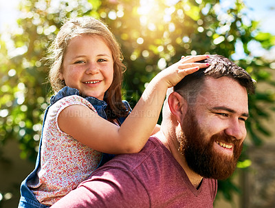 Buy stock photo Shot of an adorable little girl enjoying a piggyback ride from her father in their backyard