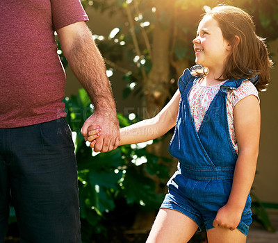 Buy stock photo Shot of a happy little girl going for a walk with her father and holding his hand