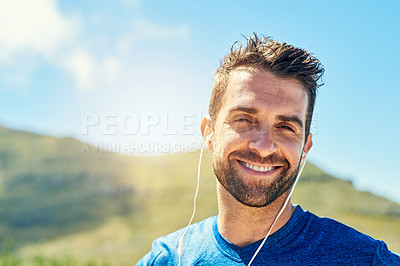 Buy stock photo Portrait of a young man listening to music while out for a run